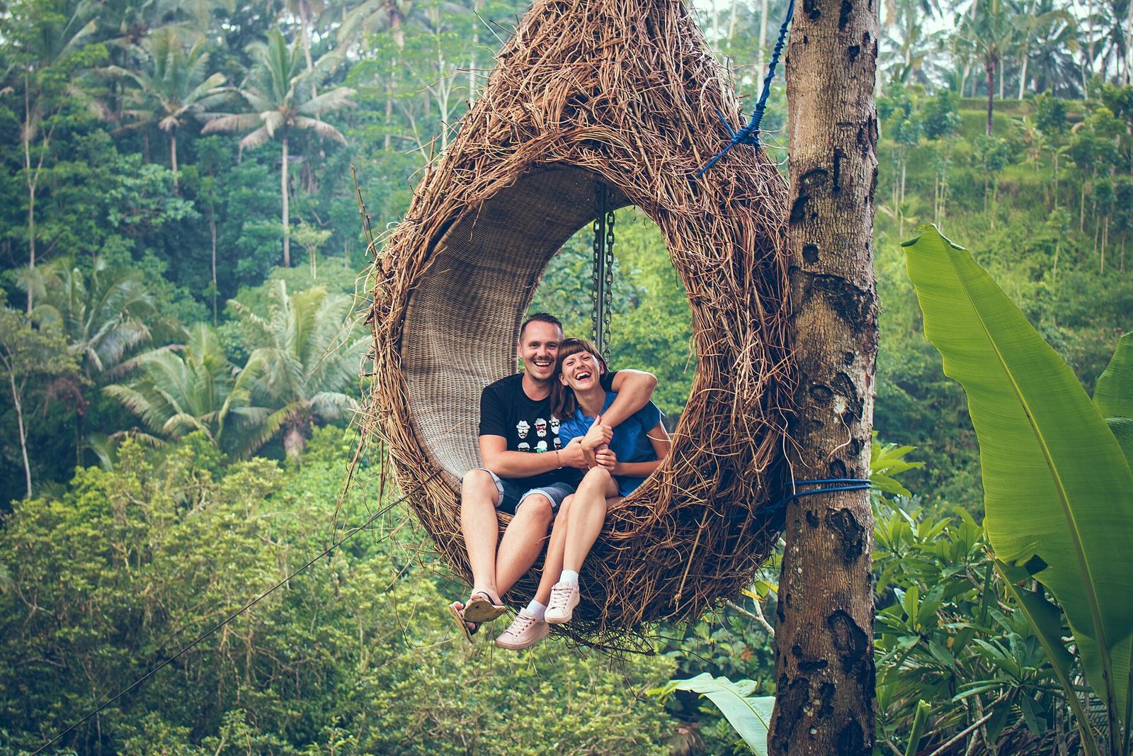 A couple in a nest swing in the Bali jungle